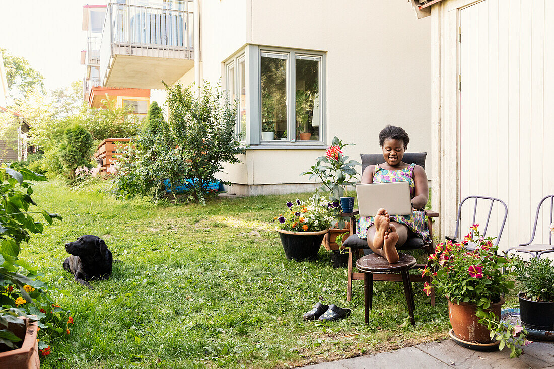 Frau mit Laptop im Garten