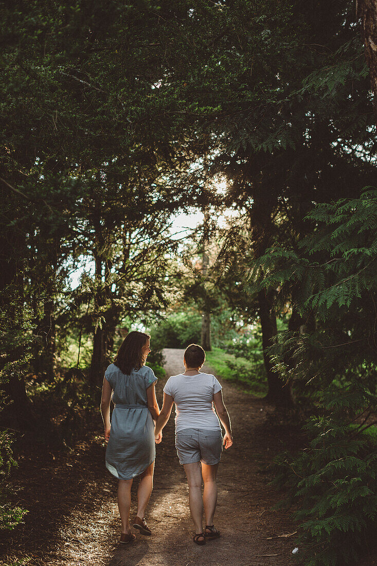 Lesbian couple walking in forest