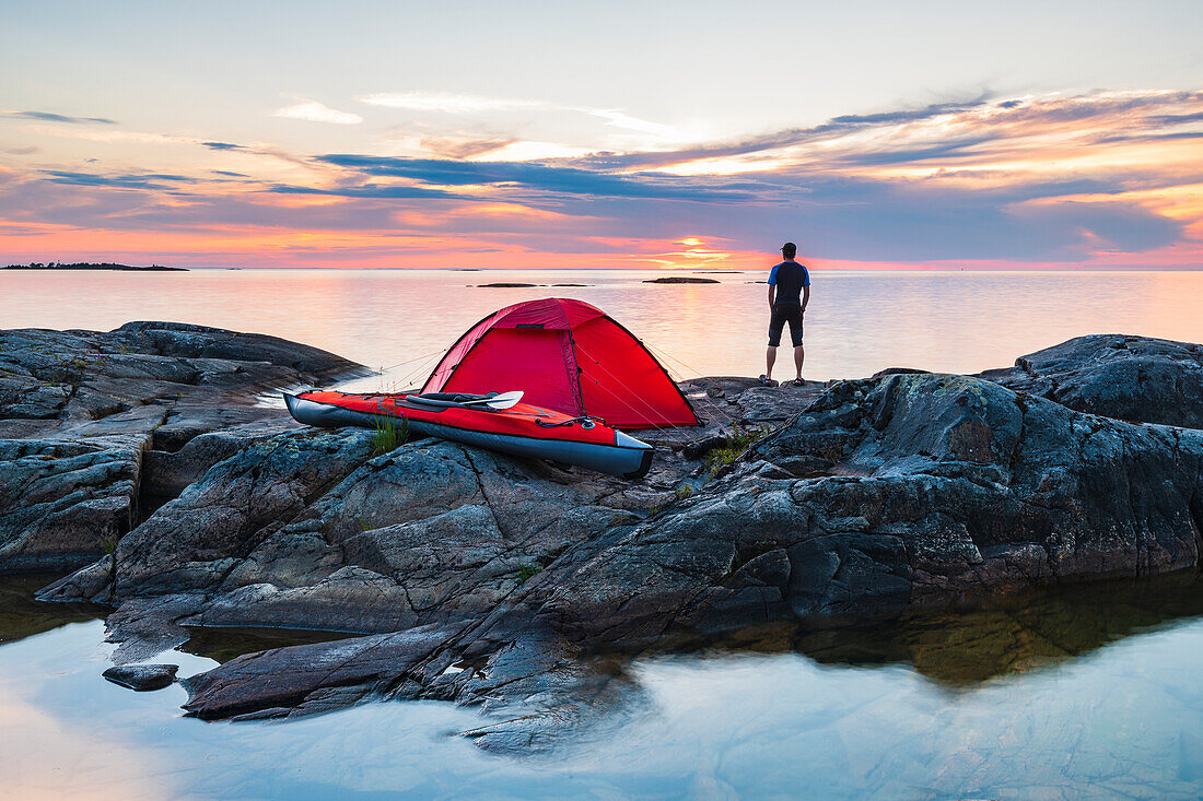 Man standing on rocks by tent