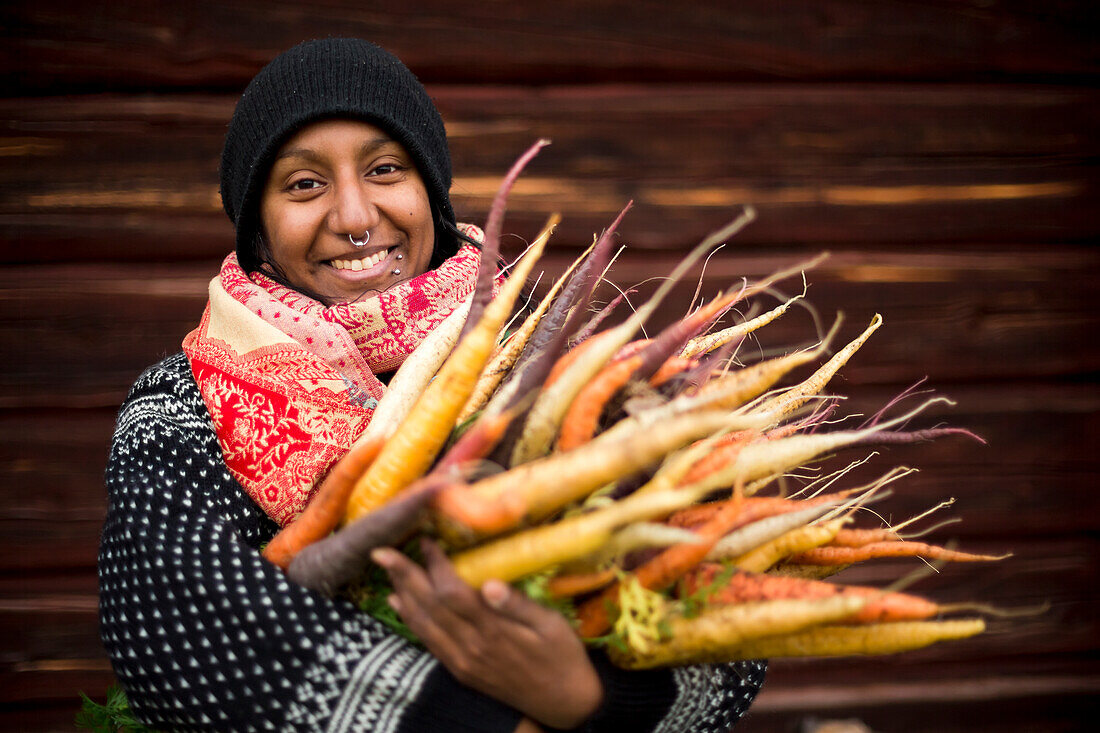 Woman holding freshly picked carrots