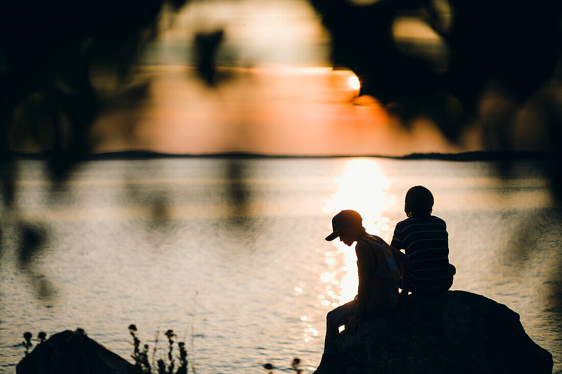 Two boys sitting on rock