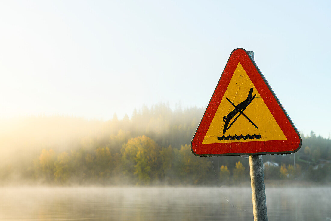 Schild "Springen verboten" am Seeufer