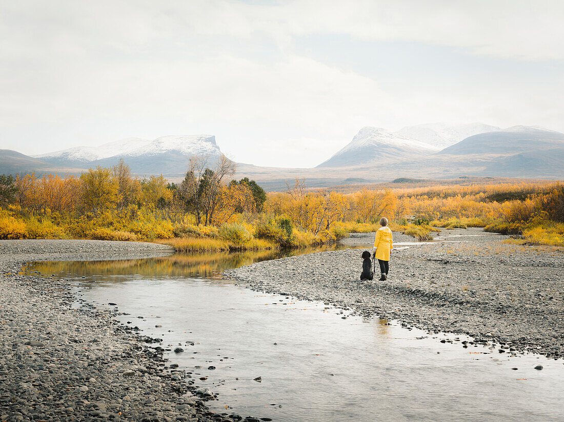 Woman and dog looking at river