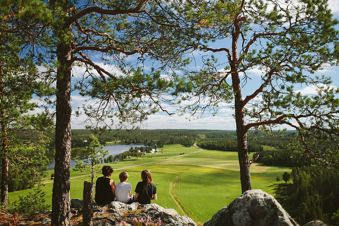 Three boys sitting on rock