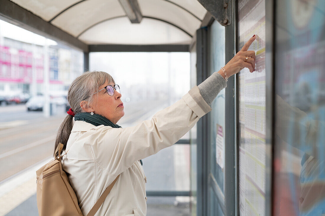 Frau an der Bushaltestelle