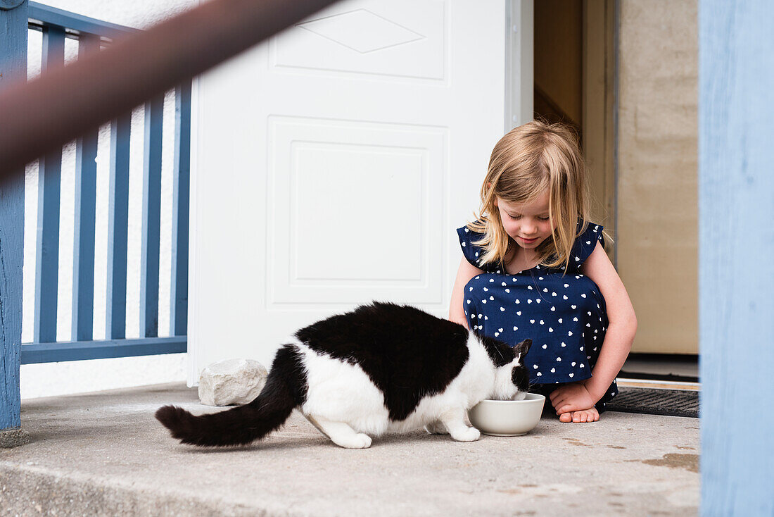 Mädchen füttert Katze