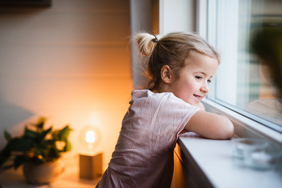 Mädchen schaut durch ein Fenster