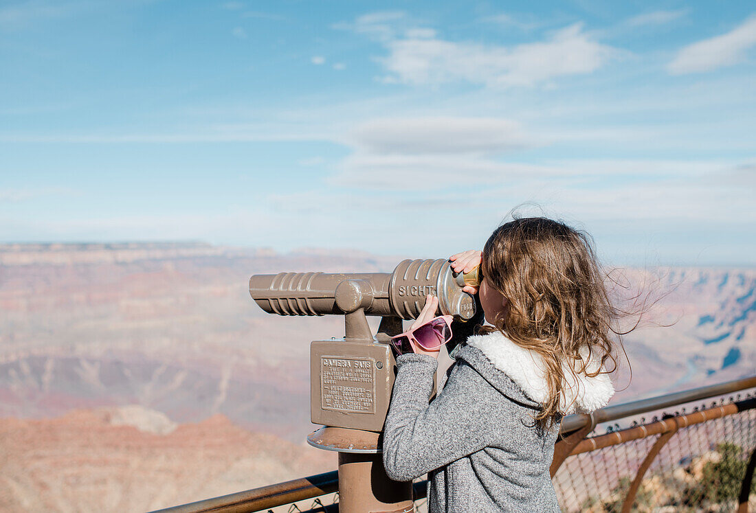 Girl looking through coin-operated binoculars