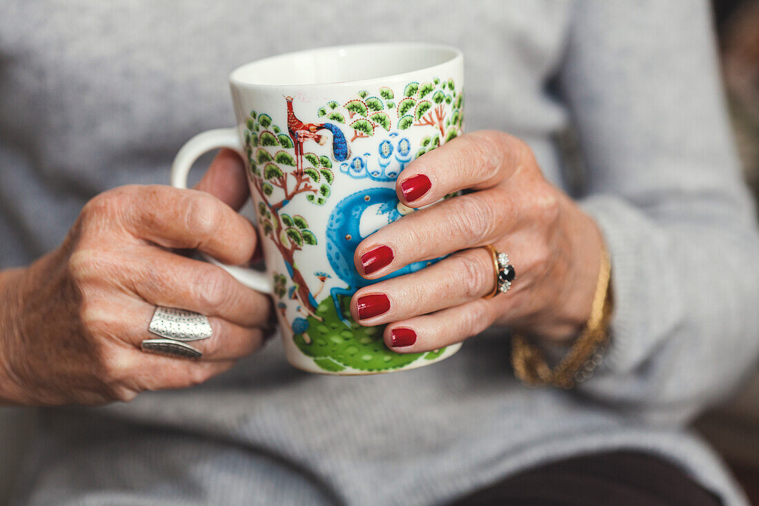 Womans hands holding mug