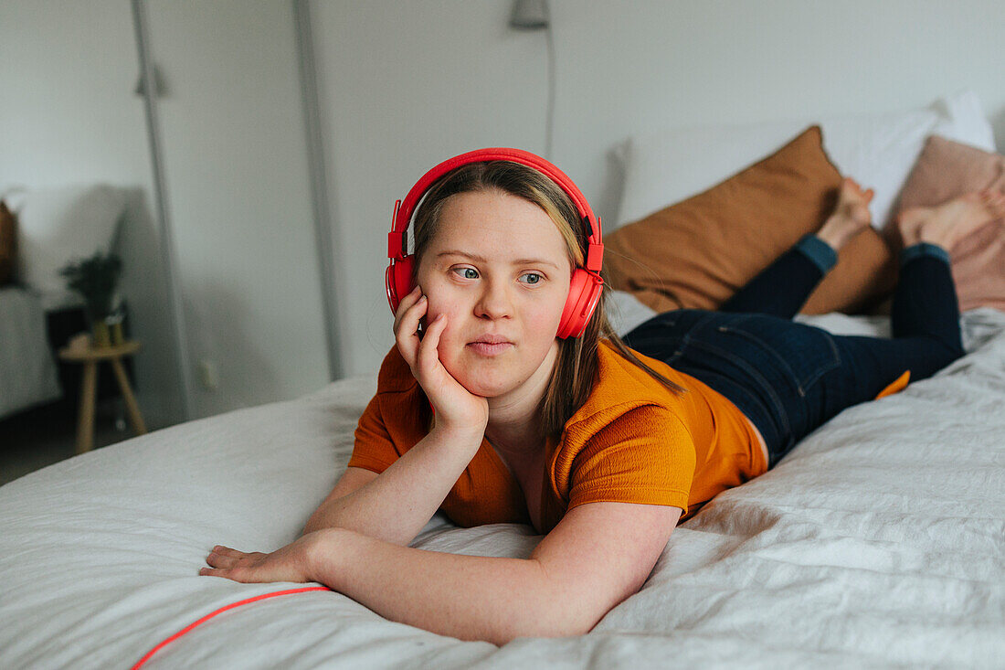 Mädchen hört Musik auf dem Bett