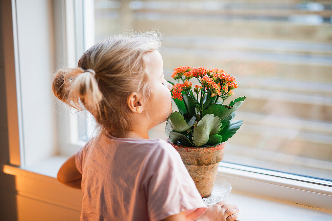 Mädchen riecht an Blumen