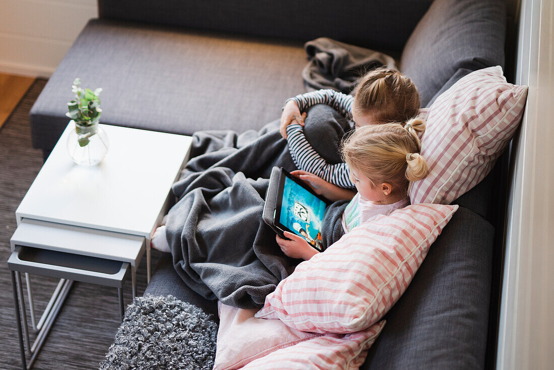 Sisters sitting on sofa