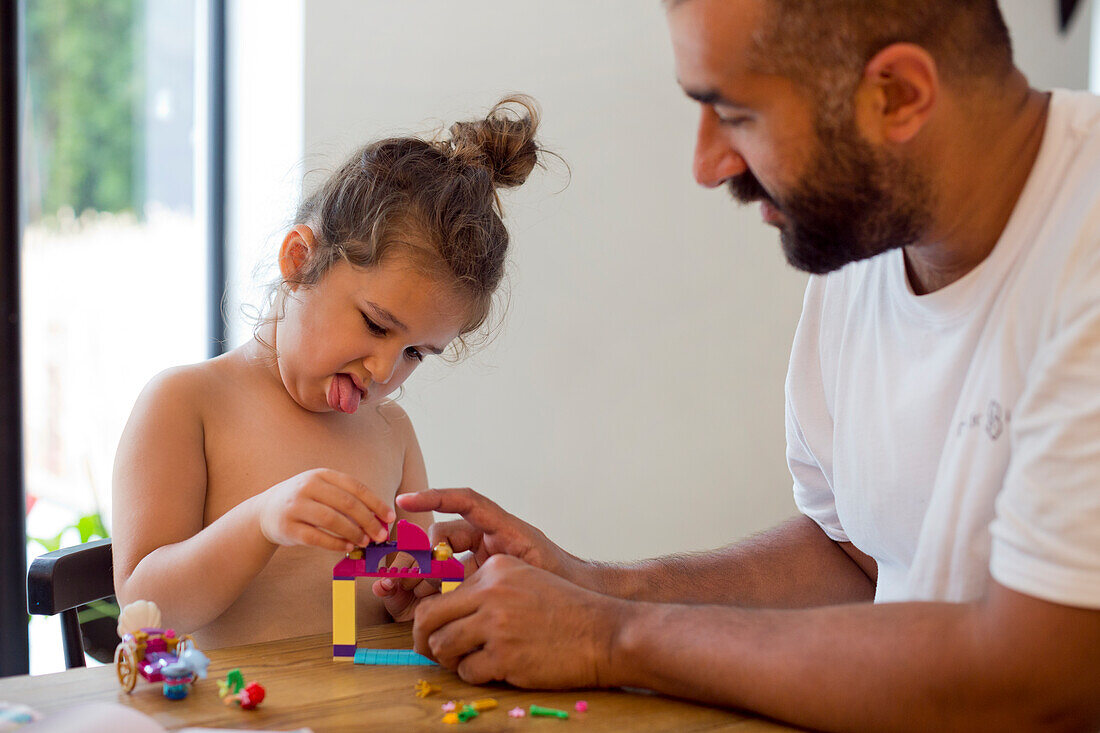 Father and daughter building Lego