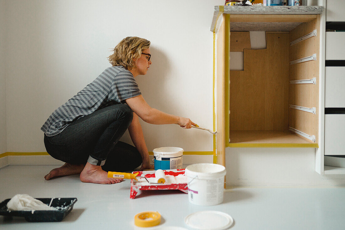Woman painting cupboard