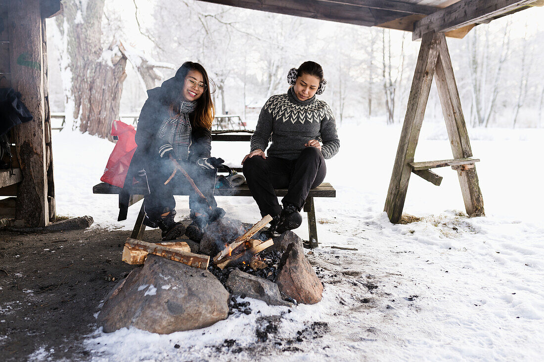 Women sitting in front of log fire