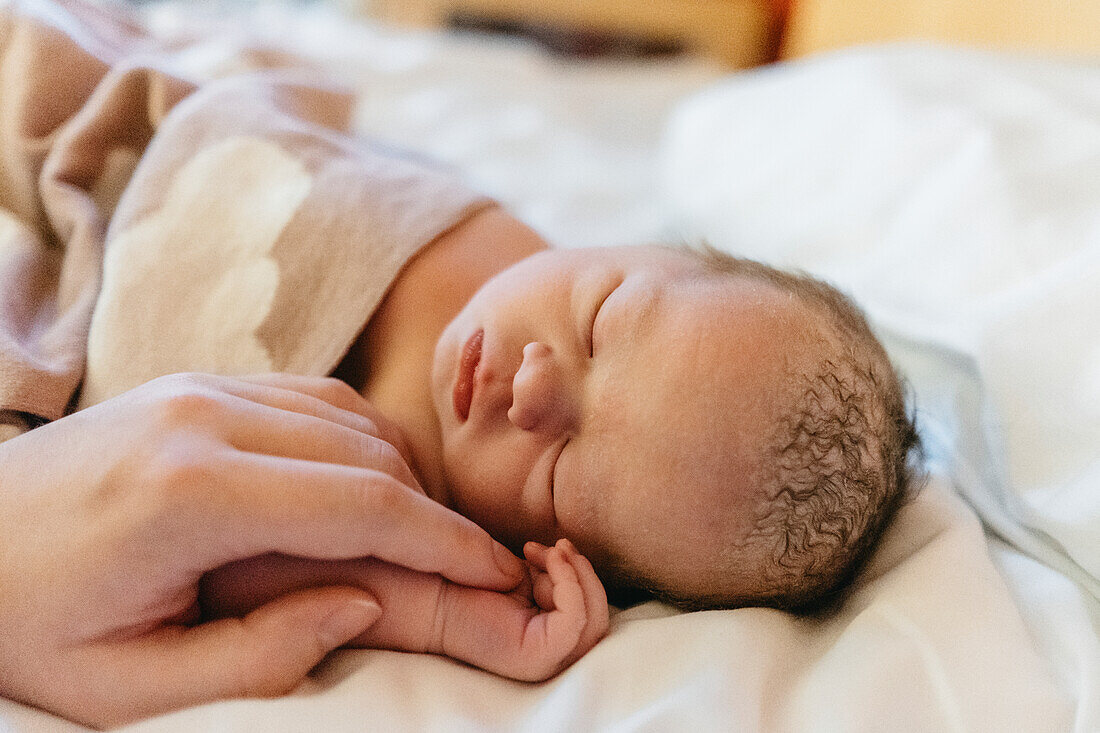 Mother holding babys hand