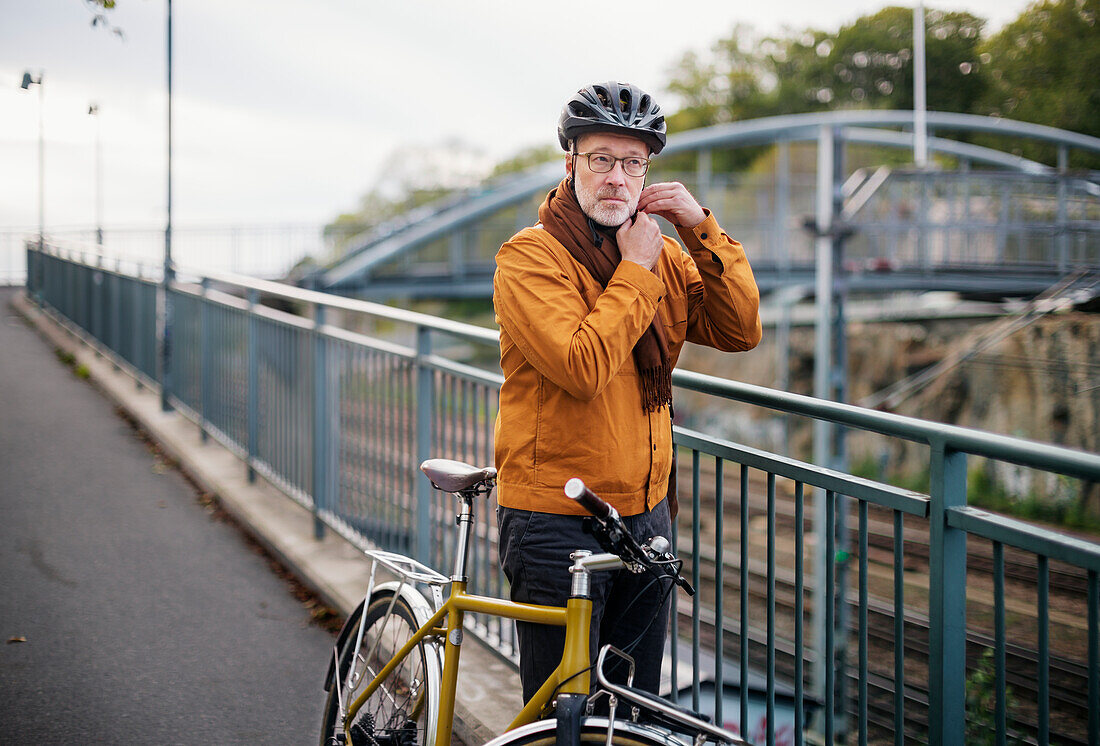 Mature man putting cycling helmet on