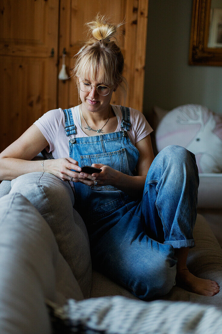 Woman using phone on sofa