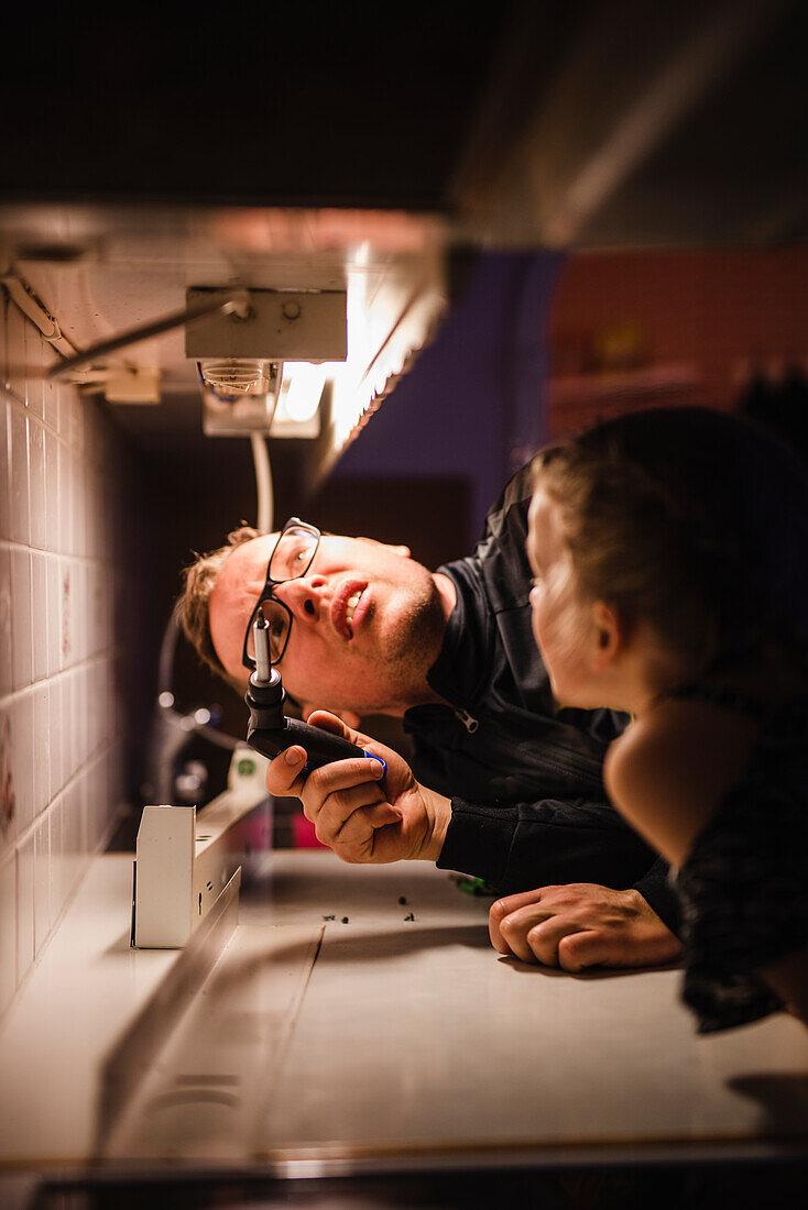 Father and daughter checking kitchen light