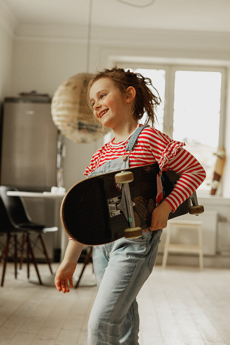 Mädchen hält Skateboard