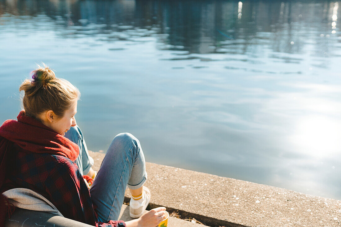 Happy woman sitting at water