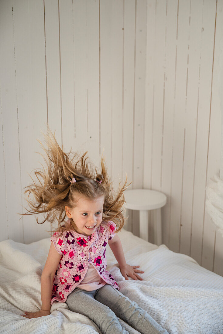 Girl jumping on bed