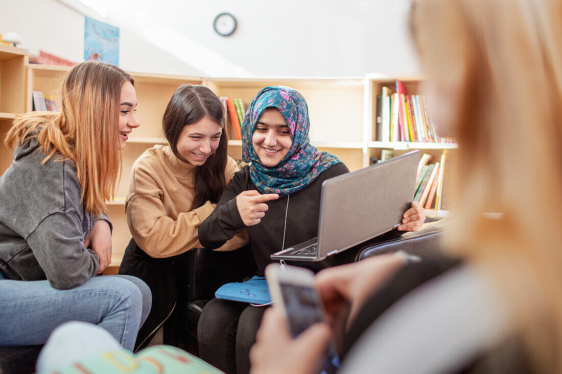 Teenage girls sitting together in library