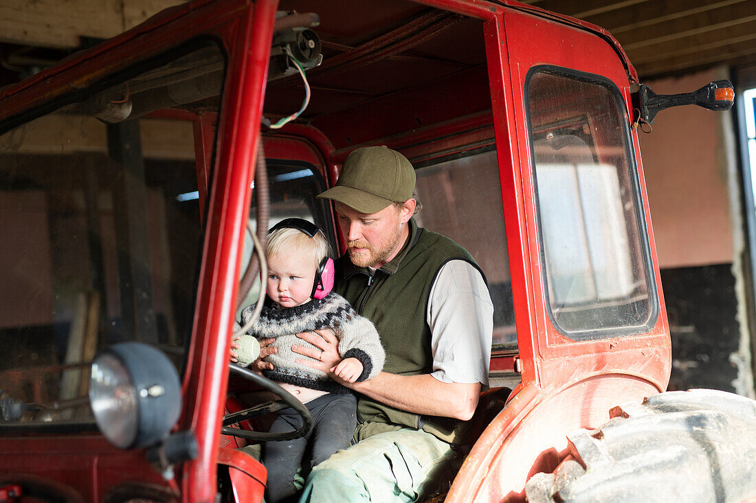 Man with toddler in tractor