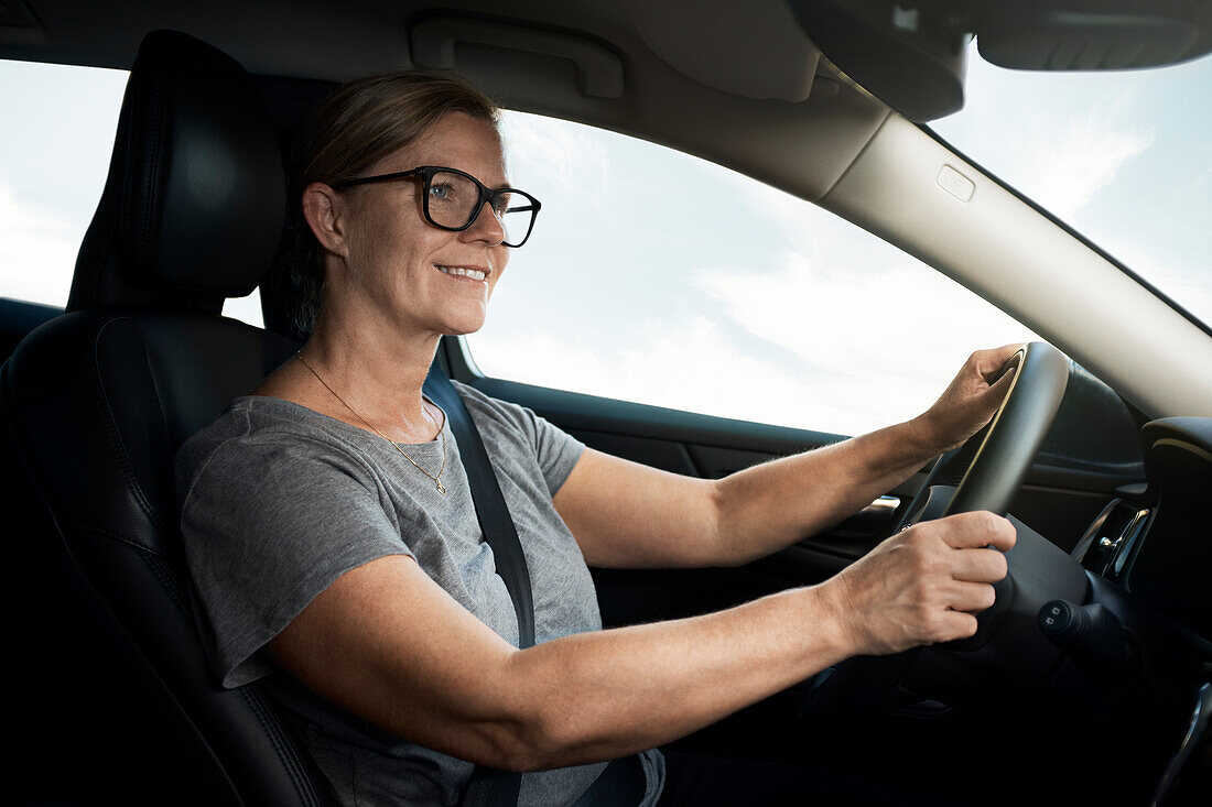 Smiling woman driving car