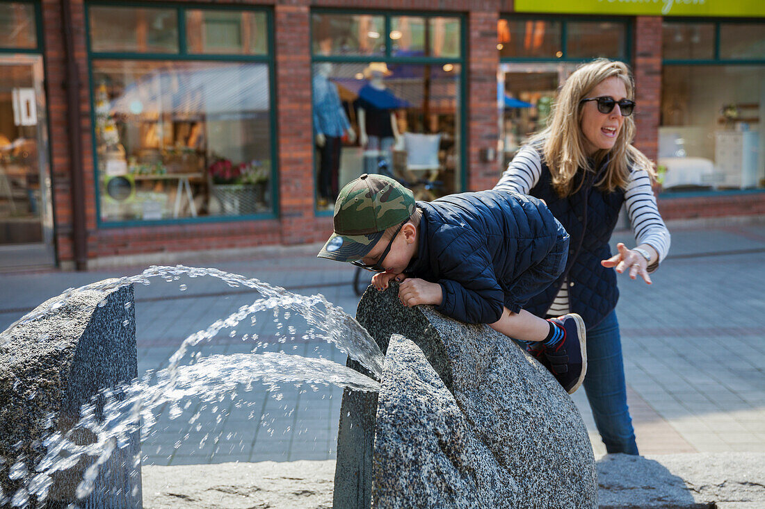 Mother with son near fountain