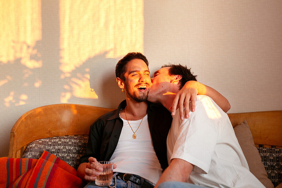 Smiling male couple sitting on sofa