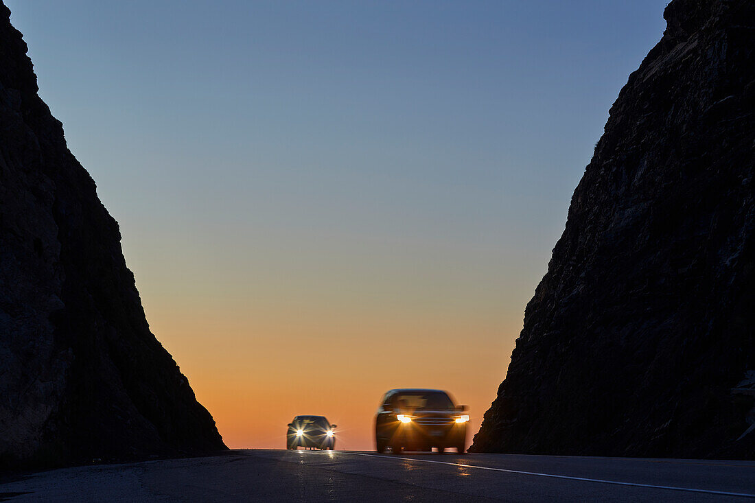 Autos auf der Straße bei Sonnenuntergang