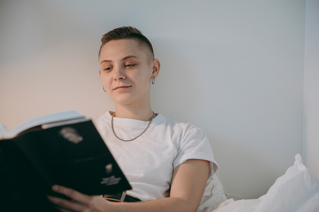 Junge Frau liest im Bett