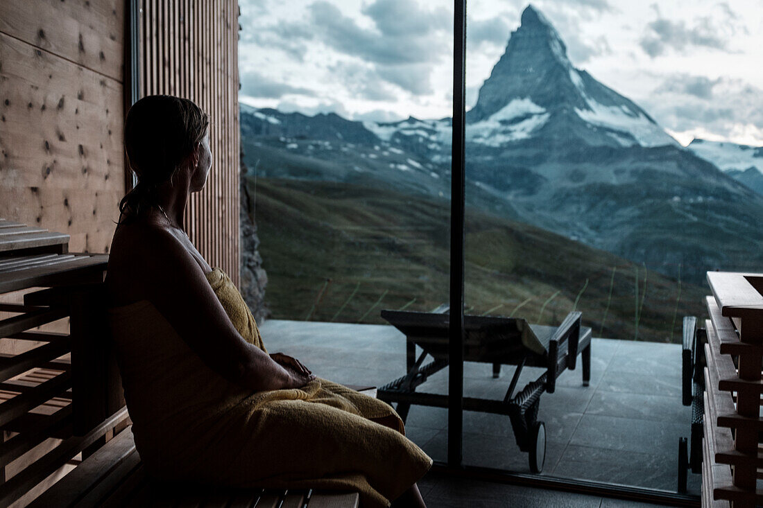 Frau schaut aus dem Fenster auf die Berge