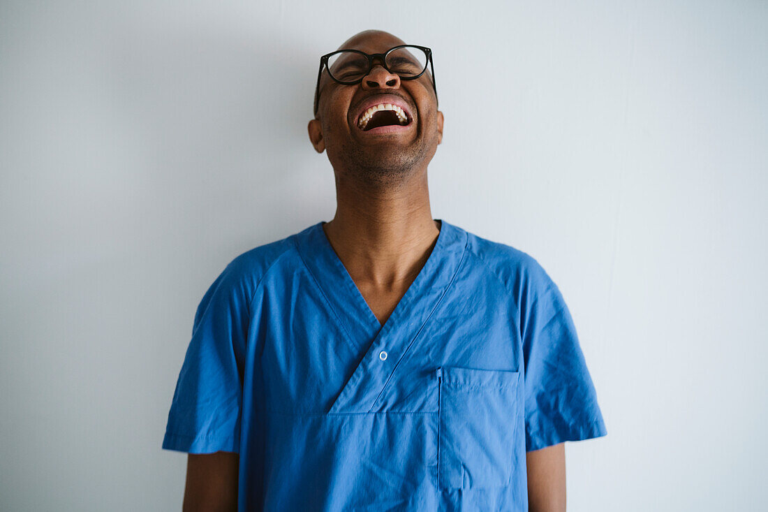 Man wearing scrubs laughing