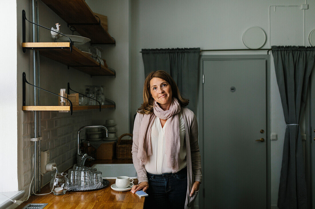 Woman in kitchen looking at camera