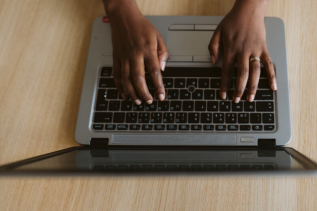 Hands typing on laptop keyboard