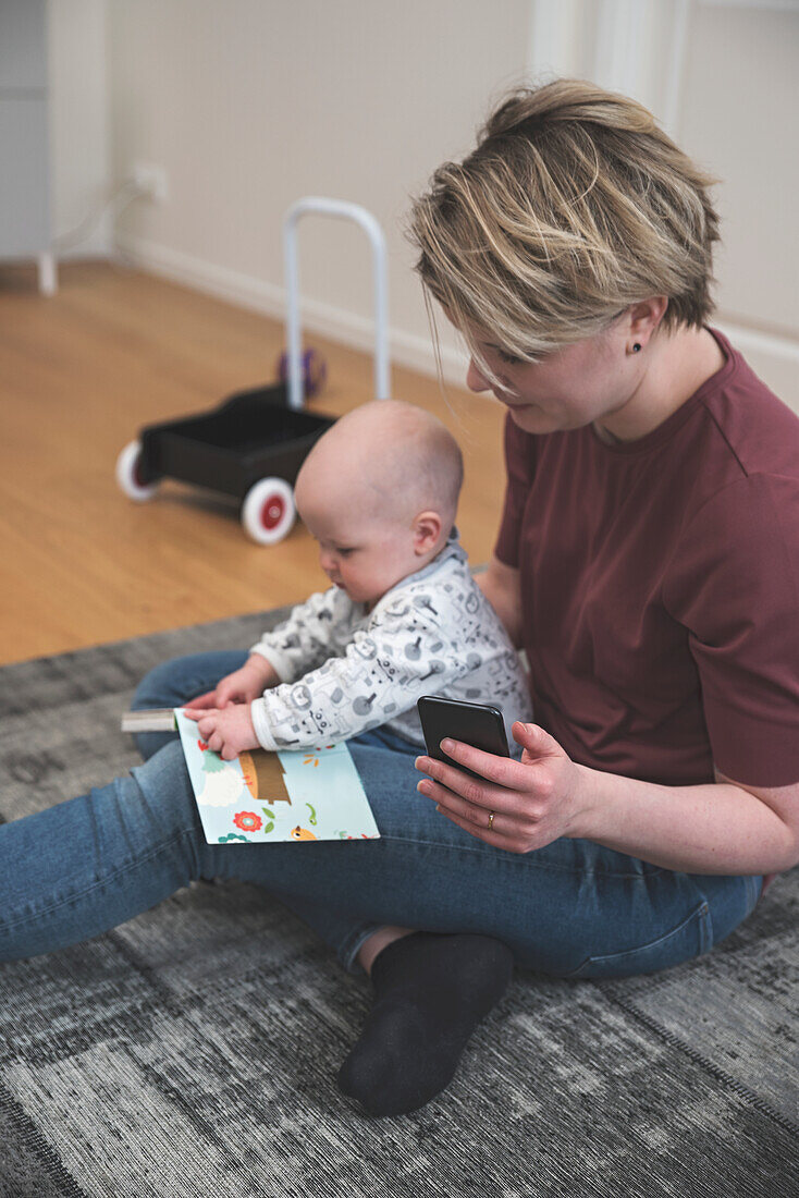 Mother with baby sitting on rug