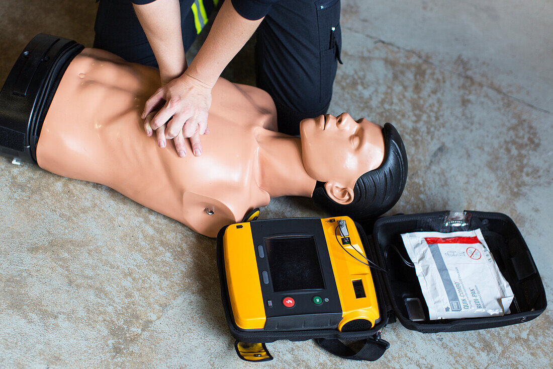 Midsection of paramedic performing cpr on mannequin