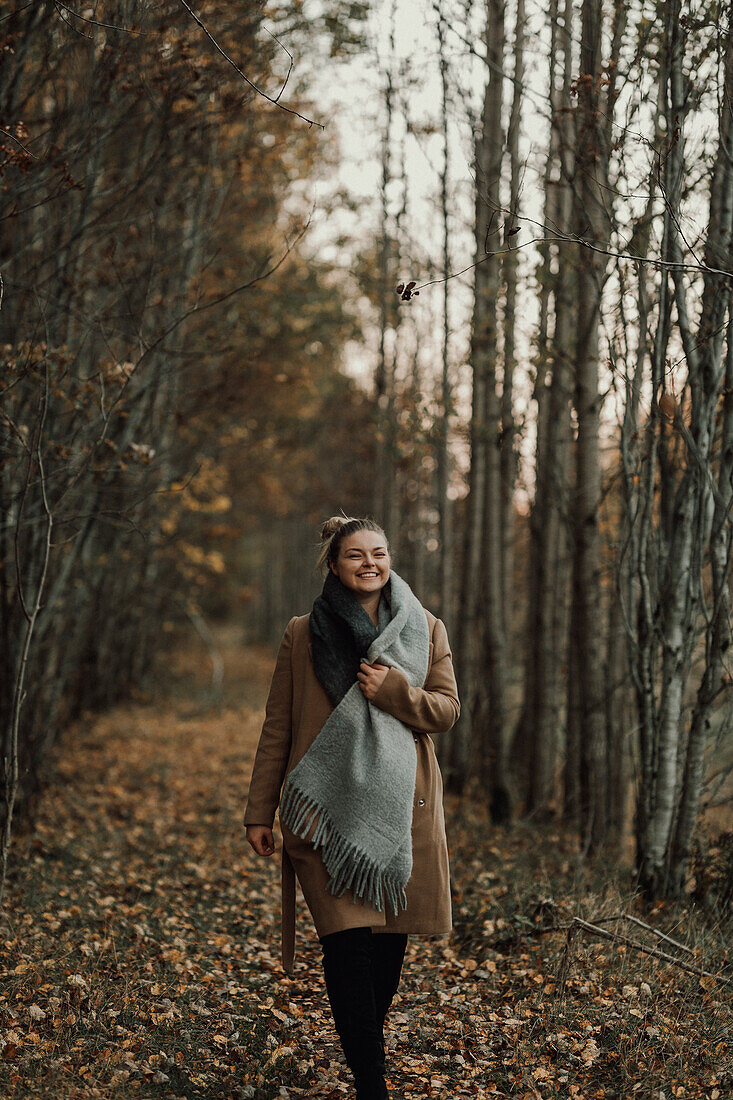 Woman walking through autumn forest