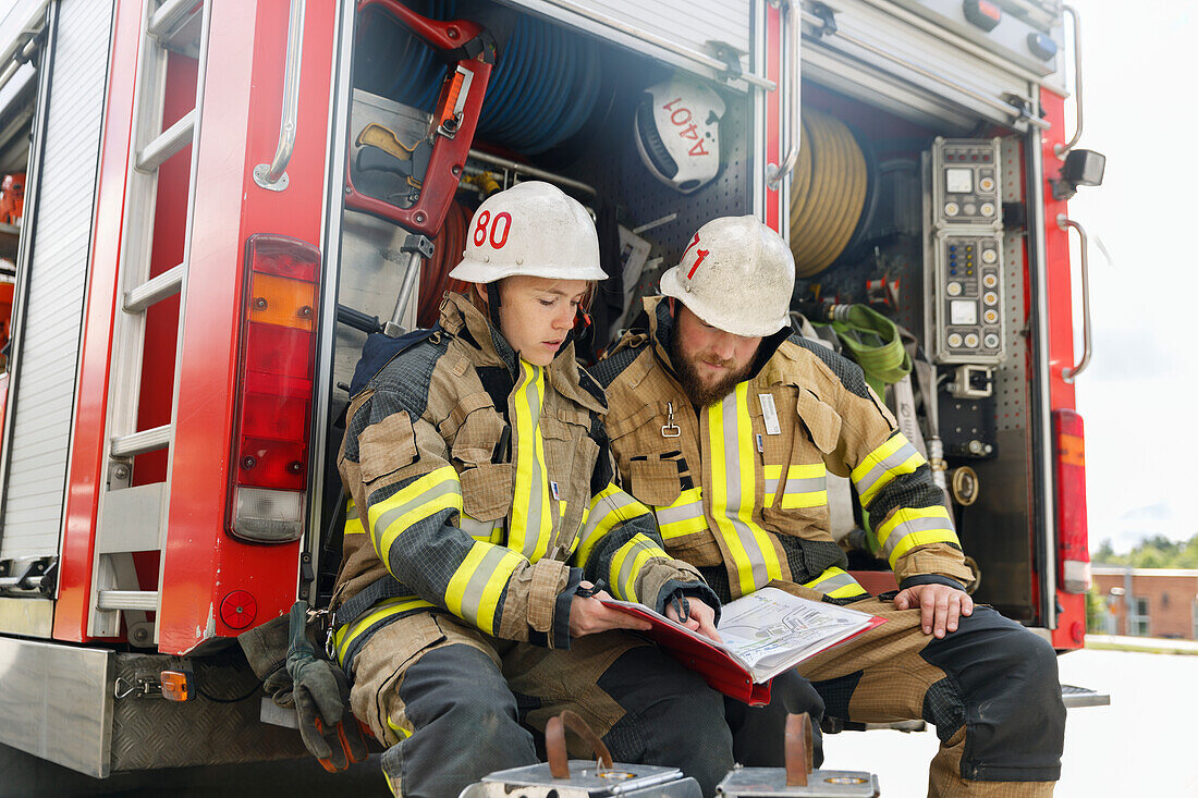 Firefighters studying documents