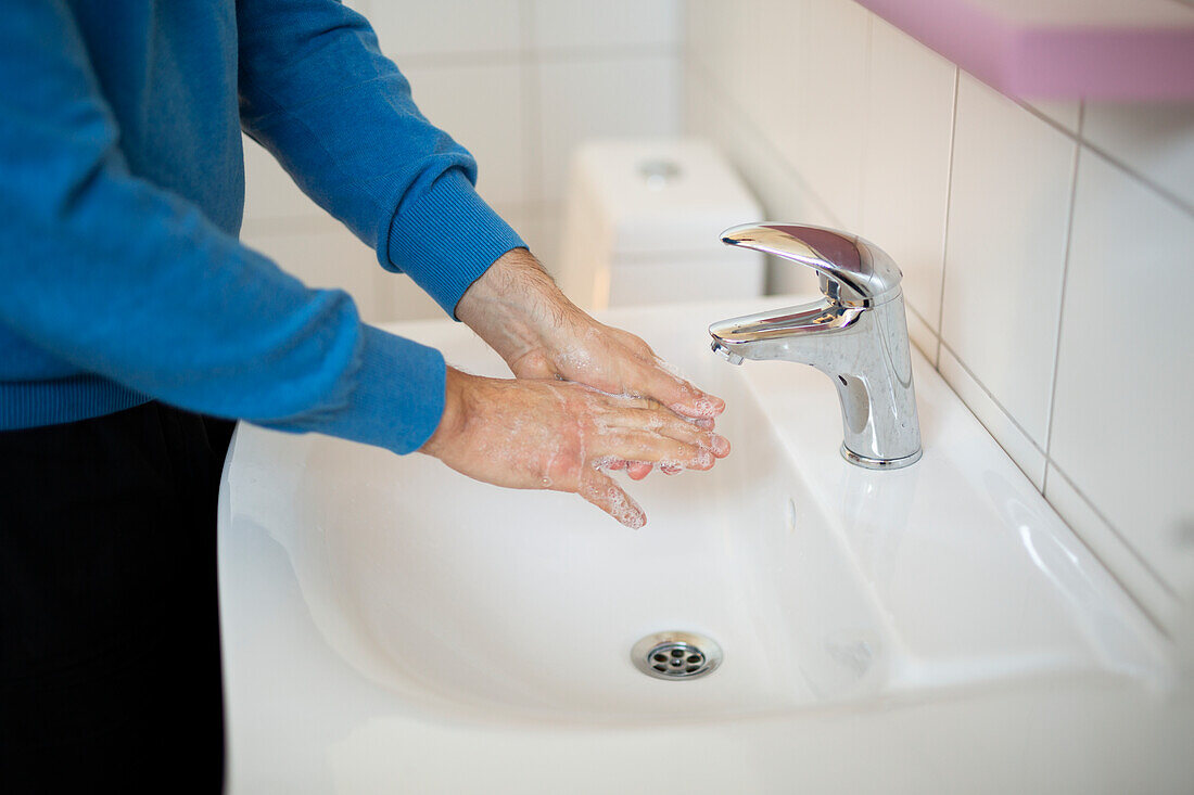 Mann wäscht sich die Hände mit Seife