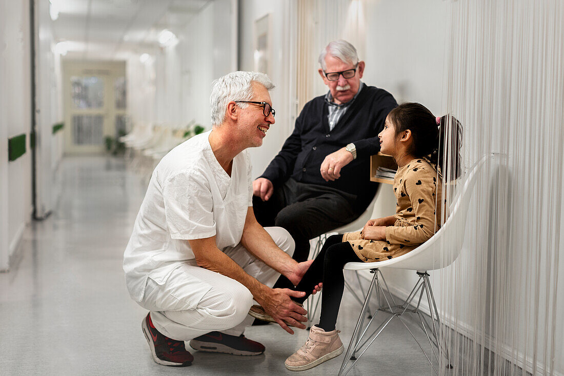 Doctor talking to girl waiting for appointment