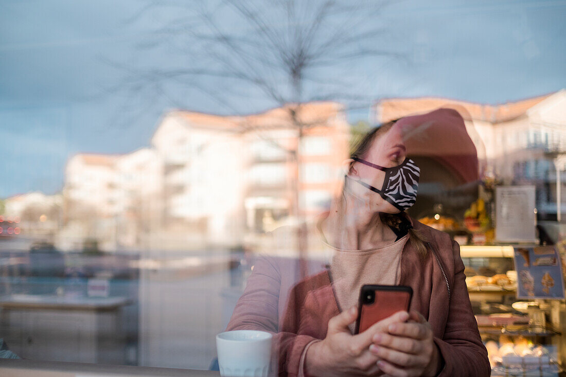 Woman with face mask using phone