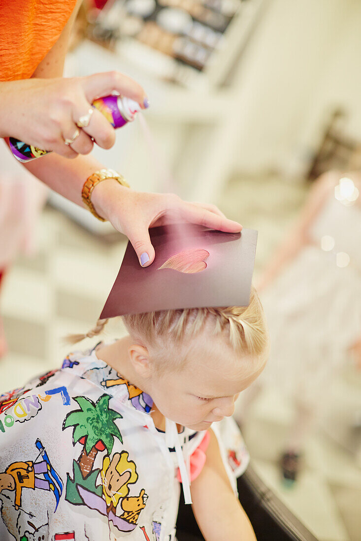 Applying spray on girls hair