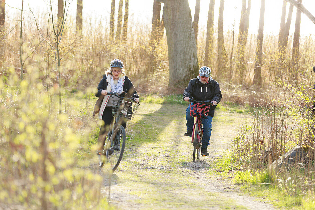 Couple cycling through forest