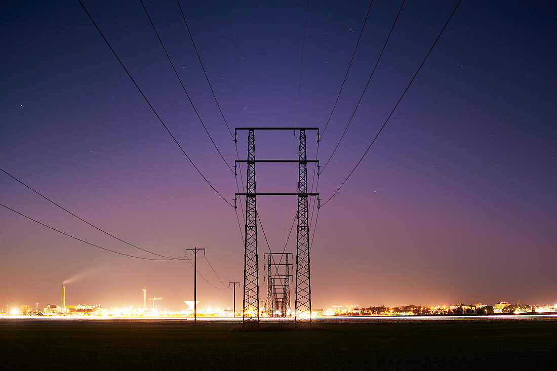 Silhouette of electricity pylon at dusk