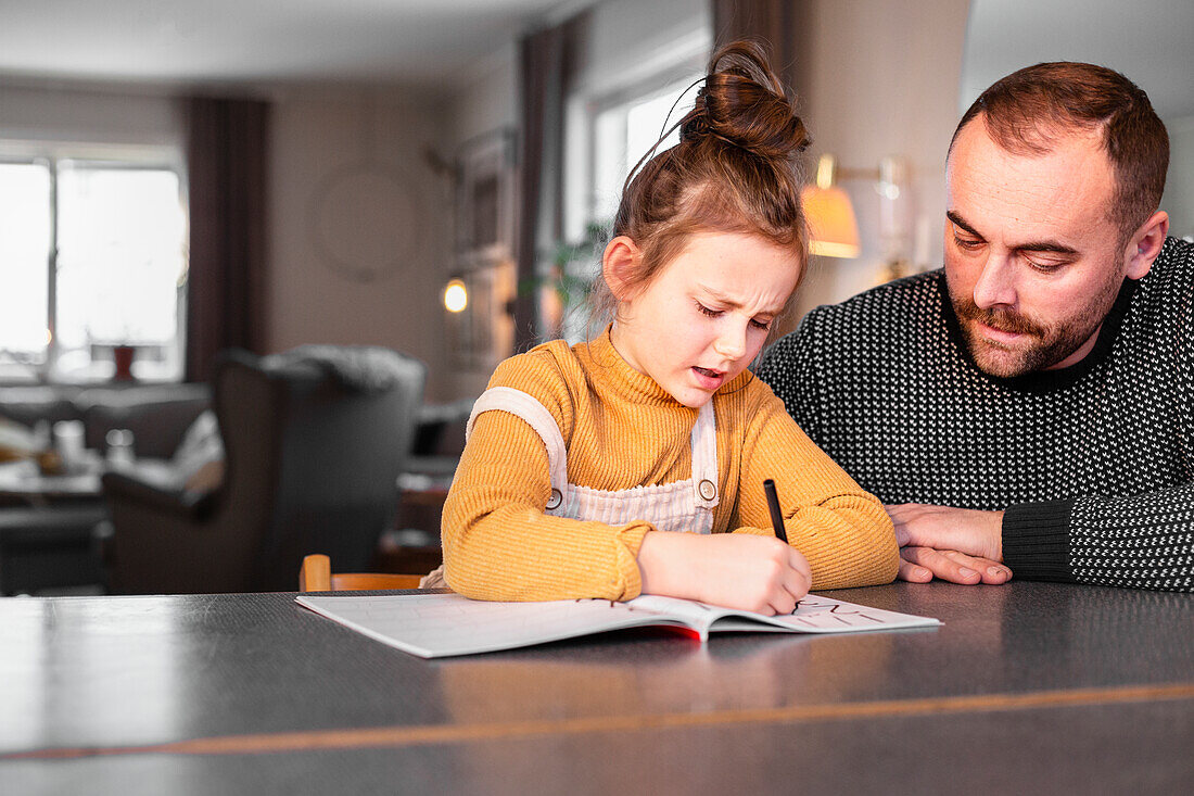 Father helping daughter with homework