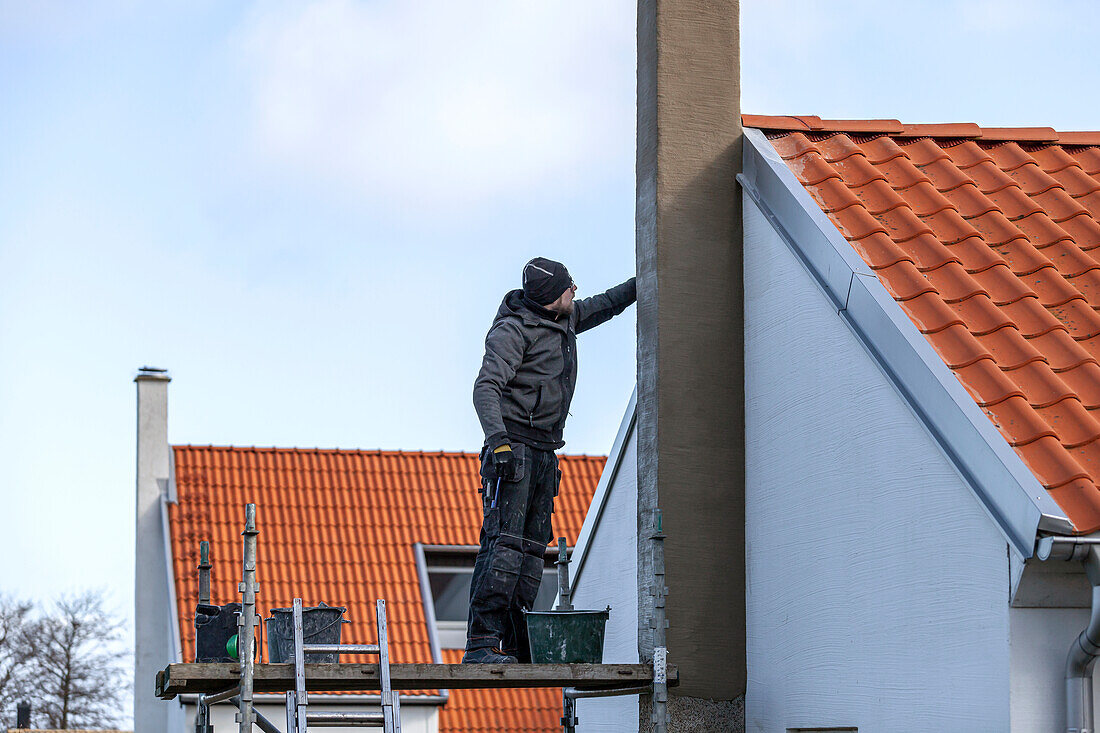 Man plastering chimney