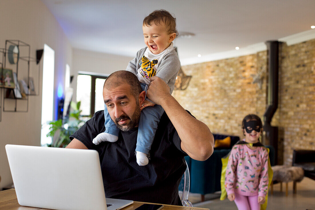 Mann mit Kindern am Laptop